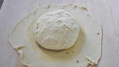 posizionala sul disco in modo che la parte con i semi sia sulla parte spennellata d’olio